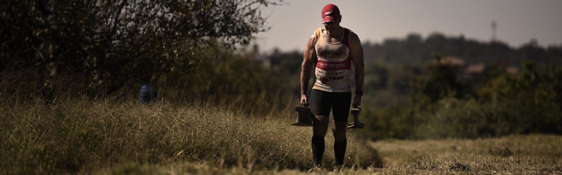 Alec Avierinos carrying weights on a trail